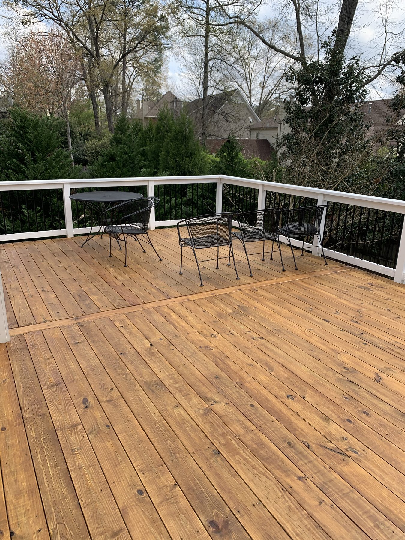 Close-up of a freshly stained and sealed wooden deck with a warm honey-colored finish.